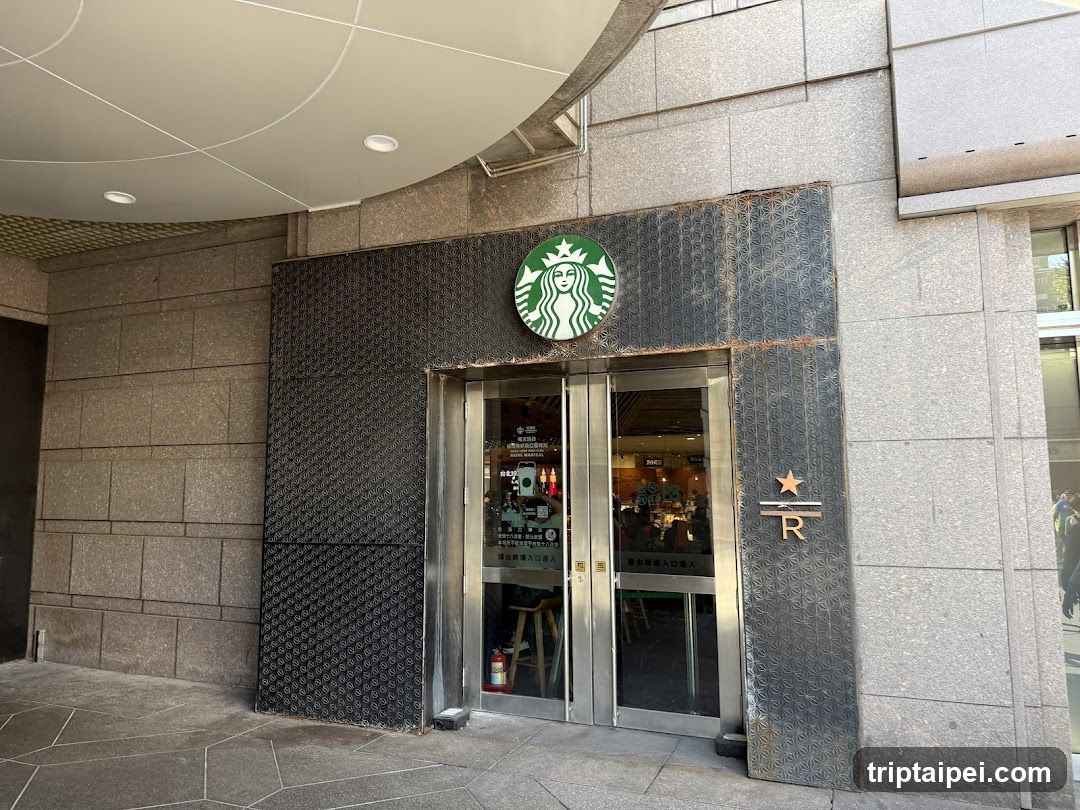 Photo of physical exterior entrance/storefront facade with visible Starbucks logo and R star emblem on building.