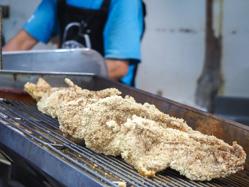 Hot Star giant fried chicken cutlets cooling on a rack at Shilin Night Market